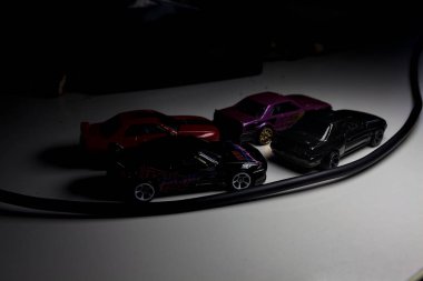 Mantova, Italy - 10TH AUGUST 2025 - Hot Wheels replicas of various Nissan Skyline models from 80s and 90s parked on a passing place of a mountain pass at night