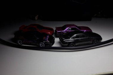 Mantova, Italy - 10TH AUGUST 2025 - Hot Wheels replicas of various Nissan Skyline models from 80s and 90s parked on a passing place of a mountain pass at night