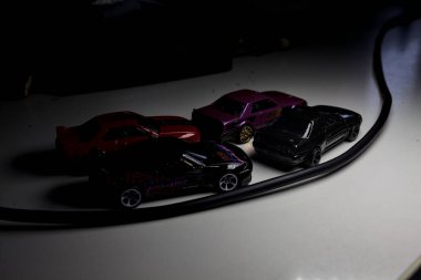 Mantova, Italy - 10TH AUGUST 2025 - Hot Wheels replicas of various Nissan Skyline models from 80s and 90s parked on a passing place of a mountain pass at night