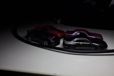 Mantova, Italy - 10TH AUGUST 2025 - Hot Wheels replicas of various Nissan Skyline models from 80s and 90s parked on a passing place of a mountain pass at night