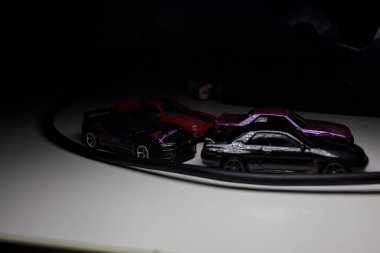 Mantova, Italy - 10TH AUGUST 2025 - Hot Wheels replicas of various Nissan Skyline models from 80s and 90s parked on a passing place of a mountain pass at night