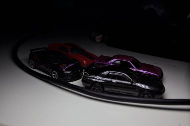 Mantova, Italy - 10TH AUGUST 2025 - Hot Wheels replicas of various Nissan Skyline models from 80s and 90s parked on a passing place of a mountain pass at night