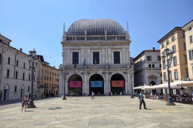 Brescia, Italy - 1ST AUGUST 2025 - Town hall in the Loggia palace in Loggia square on a sunny day with people walking by it