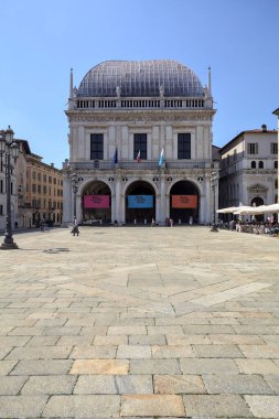 Brescia, Italy - 1ST AUGUST 2025 - Town hall in the Loggia palace in Loggia square on a sunny day with people walking by it