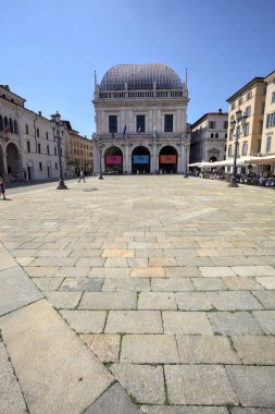 Brescia, Italy - 1ST AUGUST 2025 - Town hall in the Loggia palace in Loggia square on a sunny day with people walking by it