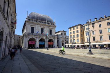 Brescia, Italy - 1ST AUGUST 2025 - Town hall in the Loggia palace in Loggia square on a sunny day with people walking by it