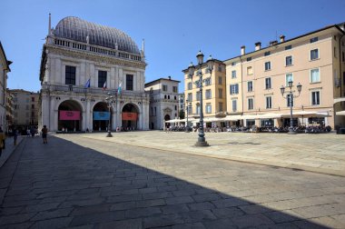 Brescia, Italy - 1ST AUGUST 2025 - Town hall in the Loggia palace in Loggia square on a sunny day with people walking by it