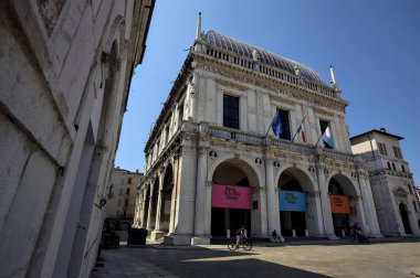 Brescia, Italy - 1ST AUGUST 2025 - Town hall in the Loggia palace in Loggia square on a sunny day with people walking by it