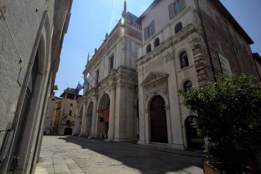 Brescia, Italy - 1ST AUGUST 2025 - Town hall in the Loggia palace in Loggia square on a sunny day with people walking by it