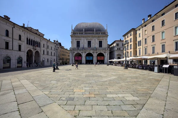 Brescia, Italy - 1ST AUGUST 2025 - Town hall in the Loggia palace in Loggia square on a sunny day with people walking by it