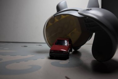 Mantova, Italy - 21ST AUGUST 2025 - Hot Wheels replica of a red 1982 Ford Fiesta MkII right outside the mouth of a toy whale in the act of eating it