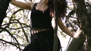 Genç seksi dansçı kadın ağaç üzerinde dans.