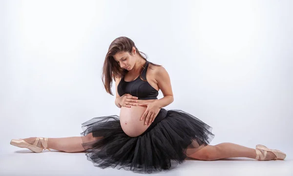 Jovem bela bailarina grávida com vestido preto . Imagem De Stock