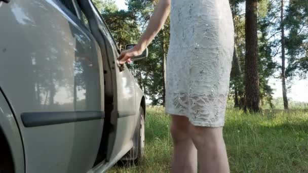 Mädchen sitzt in der Autotür im Wald 4k — Stockvideo