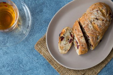 Üst manzara yaban mersini ve sıcak çayla dilimlenmiş cevizli ekmek