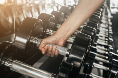 Spor salonunda el ele tutuşun. Spor salonunda ağır bir dambıl kapıyor..