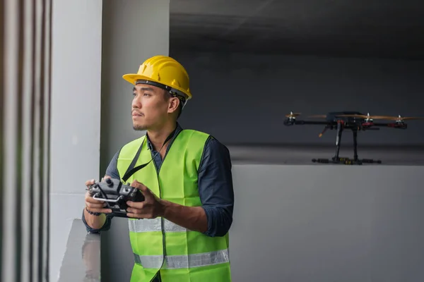 Contruction worker with drone on building site. Drone operated by construction worke