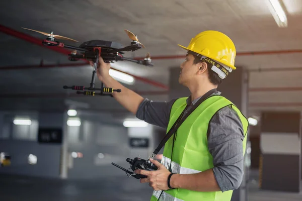 Contruction worker with drone on building site. Drone operated by construction worker