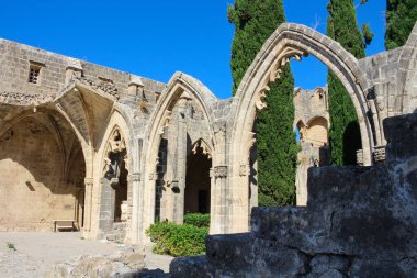 Bellapais Manastırı, Beyaz Manastır, Güzel Dünya Manastırı. Mavi gökyüzüne karşı selvi ağaçları.