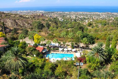  Bellapais Manastırı 'ndan güneş yatakları, palmiye ağaçları, ağaçlar, Kyrenia, deniz ve mavi gökyüzü. Kıbrıs.