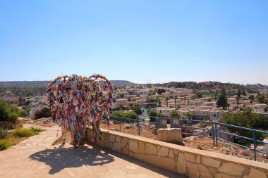 Dilek ağacı çok renkli kurdelelerde Protaras 'taki Aziz Elijah Kilisesi' nin yanındaki platformda duruyor. Kıbrıs.