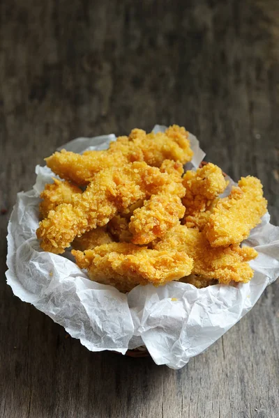 Chicken strips on wooden table — Stock Photo, Image