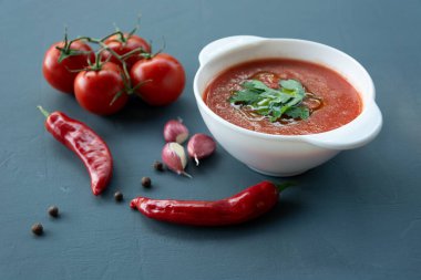 İspanyol soğuk domates çorbası çorbası beyaz bir kasede servis edilir.