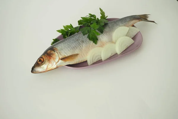 Fish. Its a whole herring. Undivided herring with onions and parsley. White background. — Stock Photo, Image