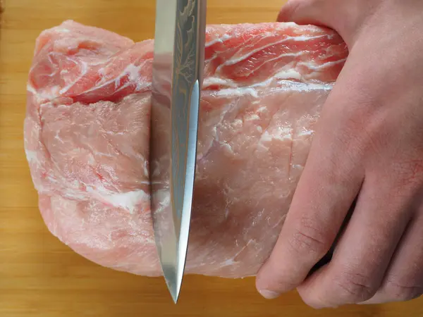 Carne fresca. O chef corta a carne em pedaços. — Fotografia de Stock