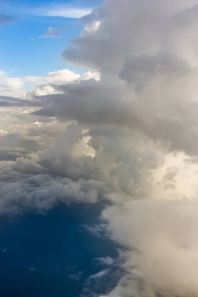 The view from the window of the plane to the ground and clouds.