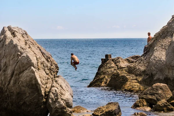 El hombre se zambulle desde el acantilado . — Foto de Stock