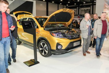 Açık kaput ile arabanın yakınında ziyaretçiler.