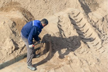 İşçi kum kazıyor.