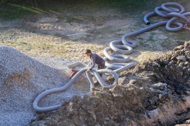 İşçi esnek boruyu düzeler.