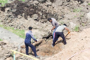 Toprak işleri üzerinde kürek olan işçiler.