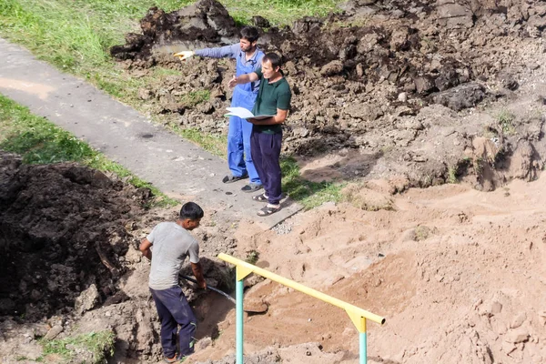 Maestro con los trabajadores en el sitio . — Foto de Stock