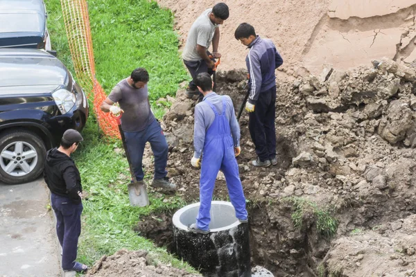 Trabajadores con palas entierran bien el hormigón . — Foto de Stock