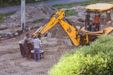 İşçiler Traktör için beton bir yüzük almak.