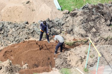 Kürekler ile işçiler hendek kum ile gömmek.