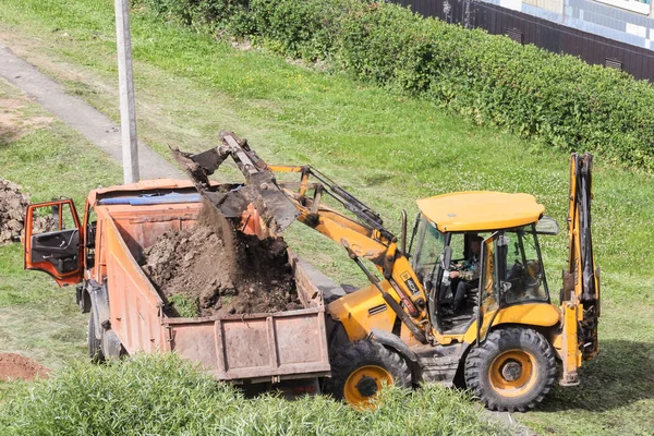 La pelle charge le sol dans un corps de camion à benne . — Photo