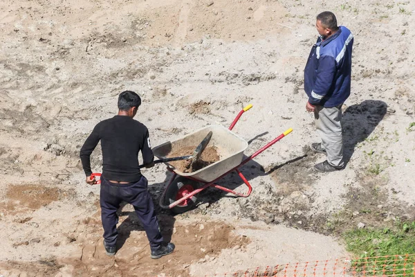 Trabajador carga el coche con arena . — Foto de Stock