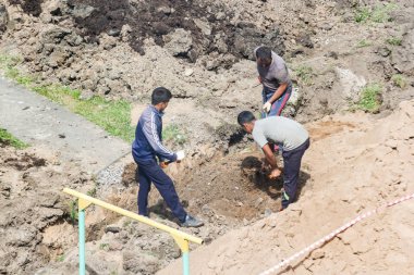Toprak işleri üzerinde kürek olan işçiler.