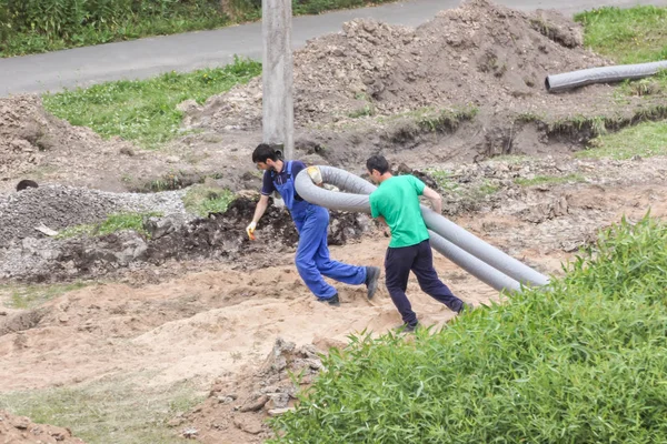 İşçiler boru yükleme yerine sürükleyin.