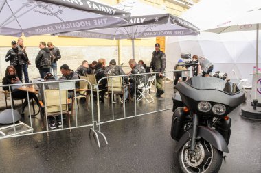 Şemsiye altında masalarda Bisikletçiler.