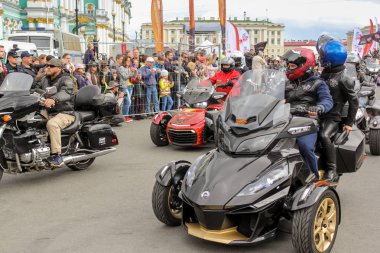 Bir grup motosikletli seyircilertarafından geçiyor.