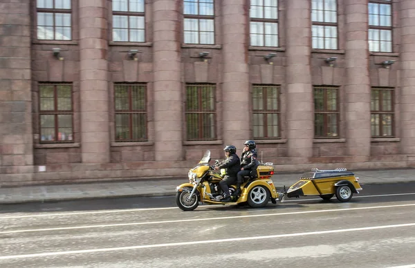 Een paar rijden een driewieler met een aanhangwagen. — Stockfoto