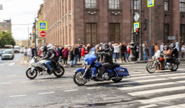 Bir grup motosikletli seyircilerin yanından geçiyor..