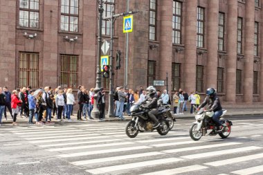 Bir grup motosikletli seyircilertarafından geçiyor.