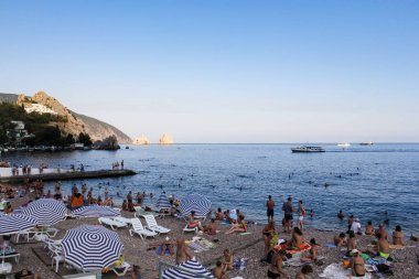 Kara plajda tatilciler.