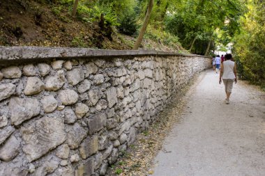 İnsanlar taştan korkuluklar boyunca yürür..